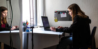 Ein Mädchen sitzt an einem Rechner und macht ihre Hausaufgaben