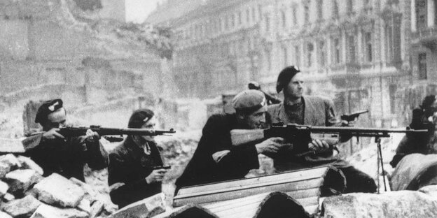 Aufständischen schießen im Warschau des Zweiten Weltkrieges.