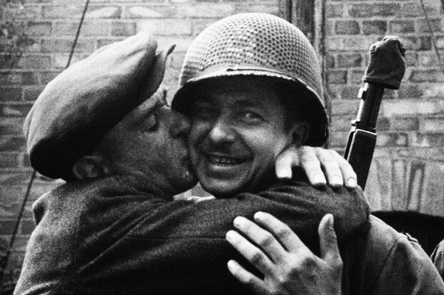 Ein befreiter Zwangsarbeiter küsst einen amerikanischen Soldaten.