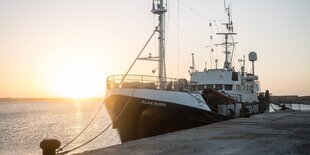 Ein Schiff im Gegenlicht an einer Kaimauer