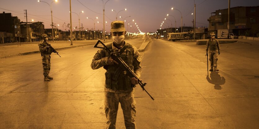 Soldaten stehen auf einer nächtlichen Straße.