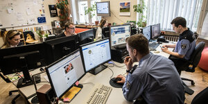 Mitarbeiter des Social Media Teams der Polizei sitzen in einem Raum im Berliner Polizeipräsidium vor ihren Computern.