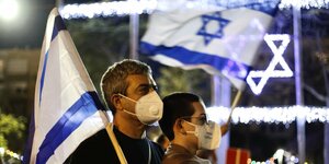 Demonstranten mit israelischer Flagge und Mundschutz