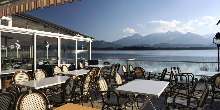 Blick von einer Restaurantterasse auf einen See.