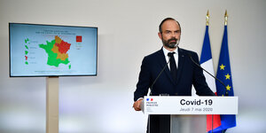 Frankreichs Premier vor einer Frankreichkarte, die, je nach Infektionsgrad in verschiedenen Zonen geteilt ist