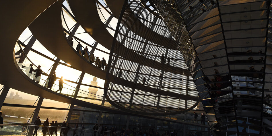 Menschen laufen durch die Kuppel des Reichstagsgebäudes
