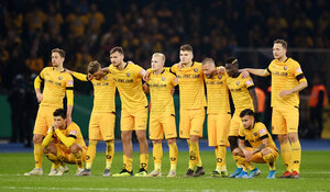 Die Spieler von Dynamo Dresden stehen in gelben Trikots nebeneinander.