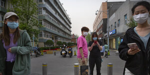 Kunden tragen Mundschutz bei ihrem Besuch einer Pekinger Freilufteinkaufsmeile.