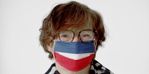 Porträt von Sabine Sütterlin-Waack mit blau-weiß-rot gestreiftem Mundschutz