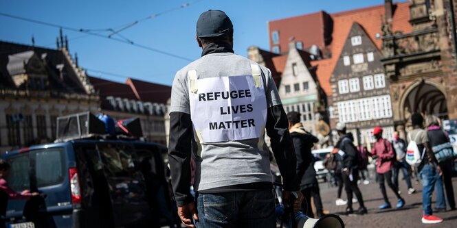 Person mit "Refugee-Lives matter"-Schild