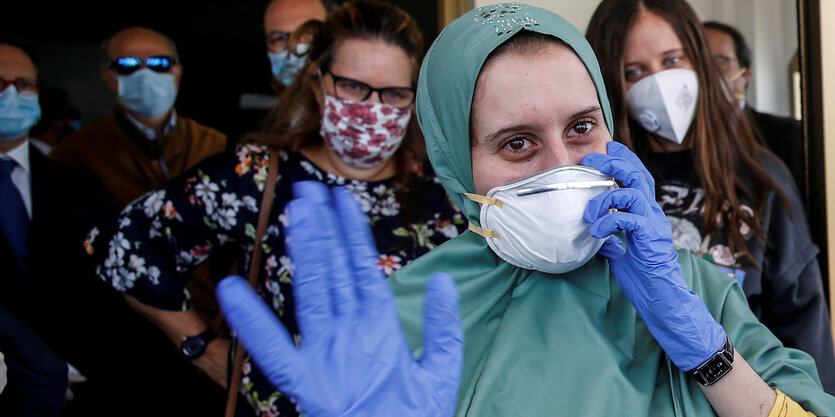 Silvia Romano mit Maske und blauen Gummihandschuhe