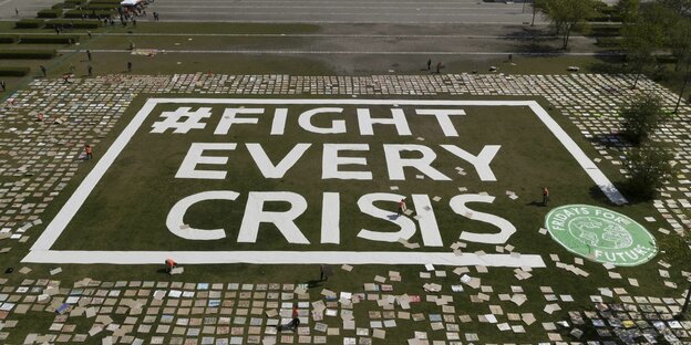 Auf Boden ausgelegte Plakate formen Schriftzug #Fight every crisis
