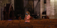 Eine Frau mit einer medizinischen Mundschutzmaske betet in der Kathedrale von Palma de Mallorca - ein Symbolbild