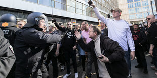 Eine Frau wird bei einer Corona-Demonstration in Berlin von Polizisten festgehalten