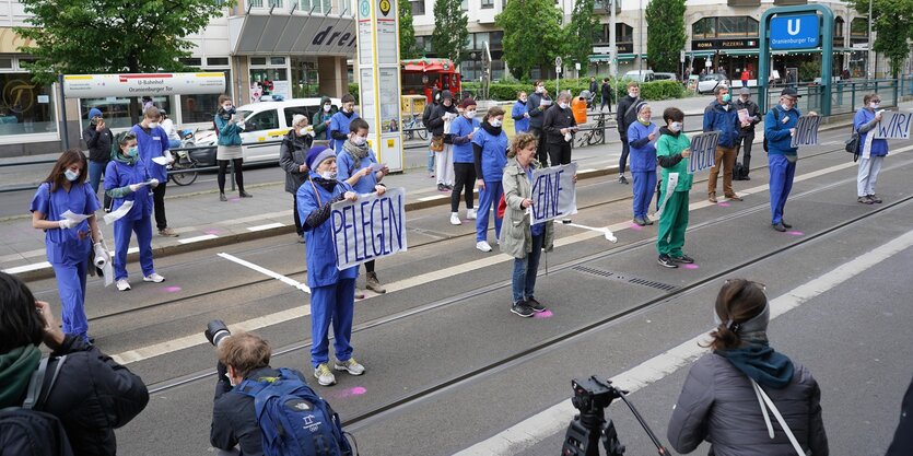 Menschen mit Mundschutzmasken nehmen vor dem Bundesgesundheitsministerium an einem Sprech-Chor vom Aktionsbündnis «Gesundheit ohne Profite» teil