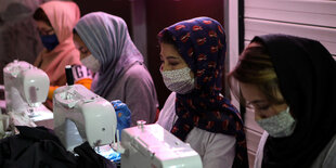 4 Frauen an Nähmaschinen produzieren maSKEN