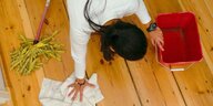 Eine Frau wischt den Boden mit einem Tuch