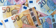 Zahlreiche Banknoten zu 10, 20 und 50 Euro liegen auf einem Tisch.