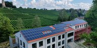 Photovoltaik auf einem Haus, dahinter wellen sich Weinberge