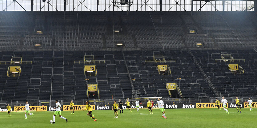 Ein Match mit dem BVB - Spieler befinden sich auf dem Rasen vor der großen, aber völlig leeren Tribüne