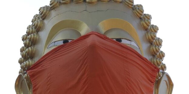 Die riesige Buddha-Statue im Tempel Wat Nithetratpradit in Thailand trägt einen Mund- und Nasenschutz
