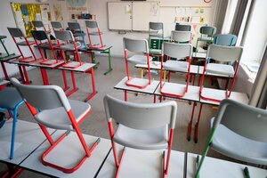 Stühle stehen auf den tischen in einem Klassenzimmer Stühle stehen auf den tischen in einem Klassenzimmer