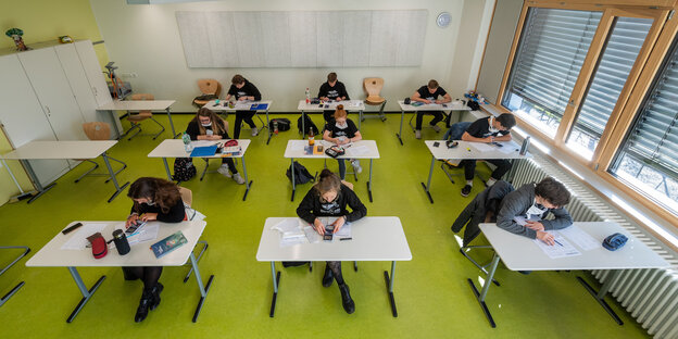 Schüler sitzen getrennt von einander im klassenzimmer