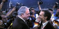 Helmut Kohl gratuliert Franz Beckenbauer zur Weltmeisterschaft, umringt von Fotografen