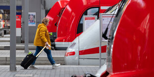 Frau mit Koffer eit zwischen Zügen