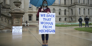 Demonstrantin mit einem Schild vor dem Parlament in Michigan. Darauf steht: Wir unterstützen diese Frau aus Michigan