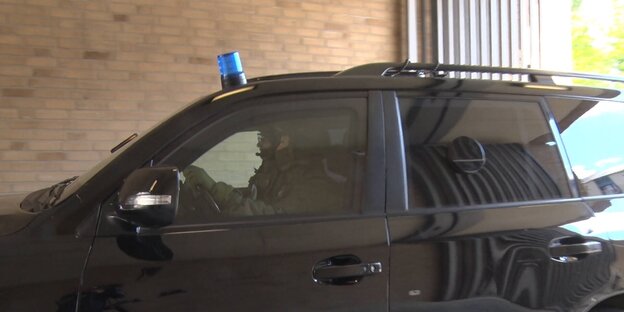 Wagen mit blauer Polizeisirene Polizisten, dunkle Scheiben lassen keinen Blick auf die Rückbank zu