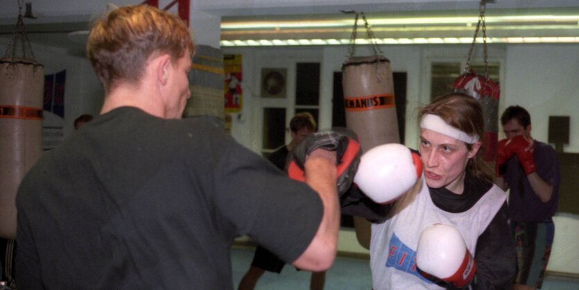 Eine Boxerin und ihr Trainer beim Trainer