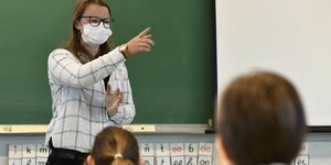 Lehrerin mit Mundschutz vor Klasse