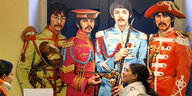 Menschen stehen vor einem großformatigen Bild der Beatles