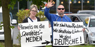Zwei Demonstranten mit Schildern auf denen steht: „Wir sind keine Rechten, wir sind keine Linken, wir sind Deutsche“