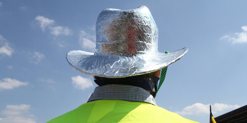 EIn Mann trägt einen mit Alufolie beklebten Cowboyhut