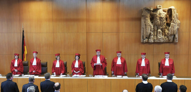 Acht VerfassungsrichterInnen bei einer Urteilsverkündung