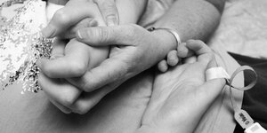 Die Hand eines Erwachsenen hält eine Kinderhand.