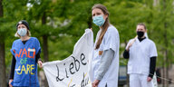 Pflegekräfte demonstrieren mit Mundschutz und Transparenten
