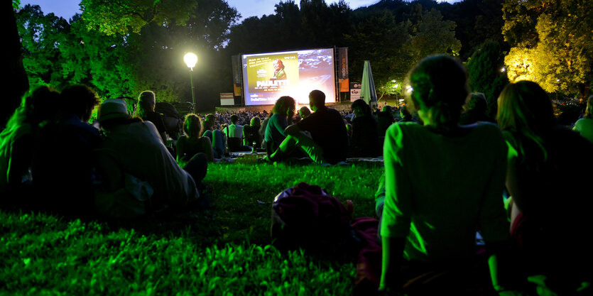 Menschen sitzen im Freiluftkino