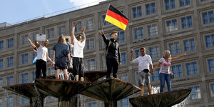 Demonstranten mit deutschlandfahnen im Brunnen am Alexanderplatz