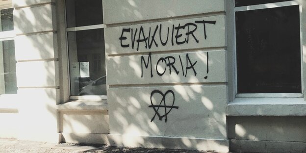 An einer Hauswand steht der Schriftzug "Evakuiert Moria!"