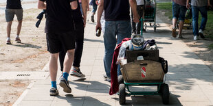 Mit einem Bollerwagen und Bierflaschen in den Händen ziehen junge Leute am Vatertag durch Hannover.