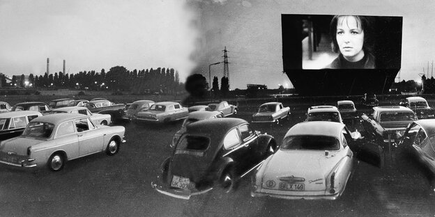 Einige Autor vor einer Leinwand, auf der eine Frau zu sehen ist - ein Foto aus alten Tage, dass das Autokino in der Siemensstadt von 1966 zeigt