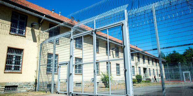 Ein Gitter mit Stacheldraht vor einem Gebäude