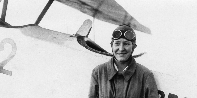 Marga von Etzdorf vor einem Flugzeug.