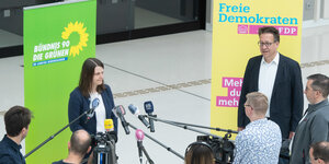 Zwei Politiker stehen vor Mikrofonen in der Halle des niedersächsischen Landtages.
