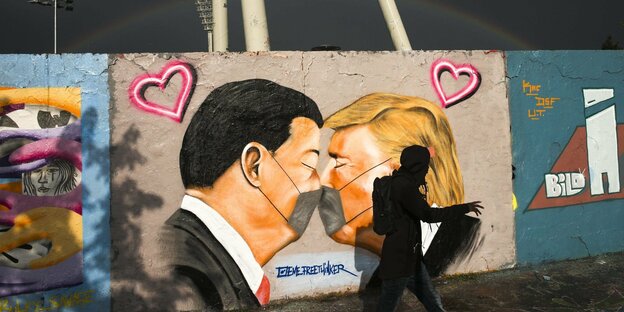 Auf einem Grafitti sieht man den US-Präsidenten, wie er mit Maske Chinas Präsidenten küsst