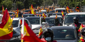 Ein langer Autokorso ist zu sehen, die Fahrerinnen und Fahrer schwenken die Spanienflagge