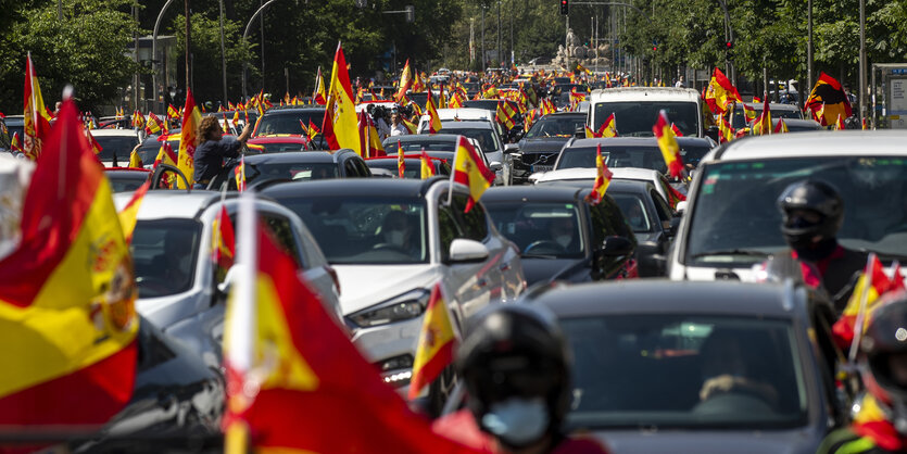 Ein langer Autokorso ist zu sehen, die Fahrerinnen und Fahrer schwenken die Spanienflagge